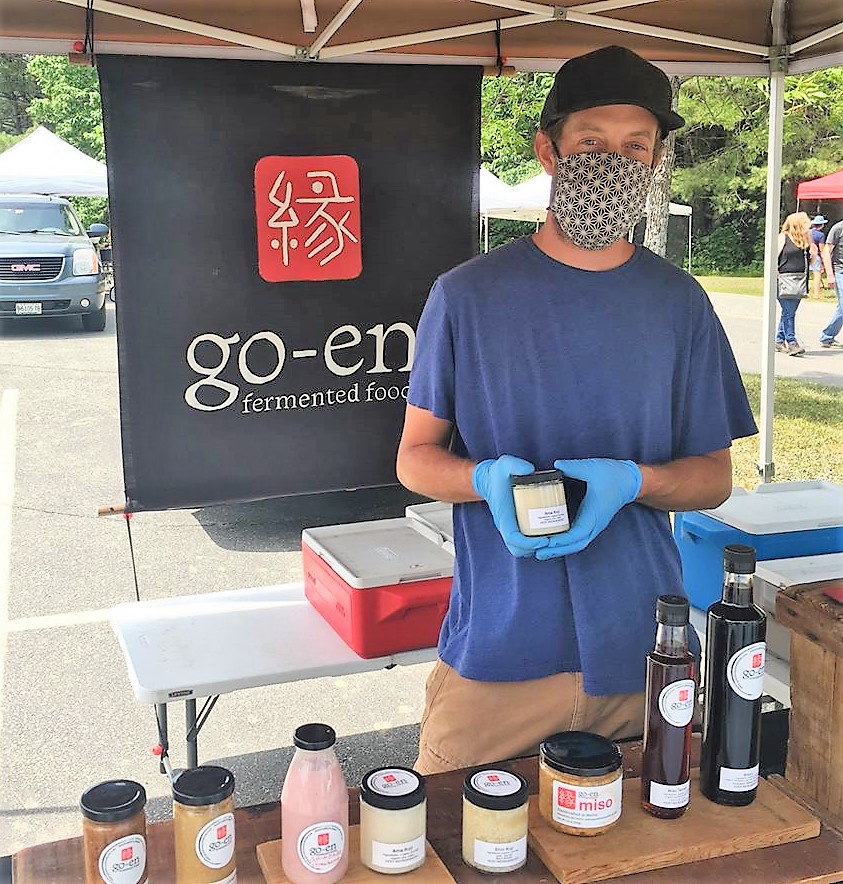 With vendors and shoppers exercising caution, we can safetly enjoy Maine agriculture at farmers' markets. A food producer wearing a protective mask poses for a picture at a Farmers' Market in Maine