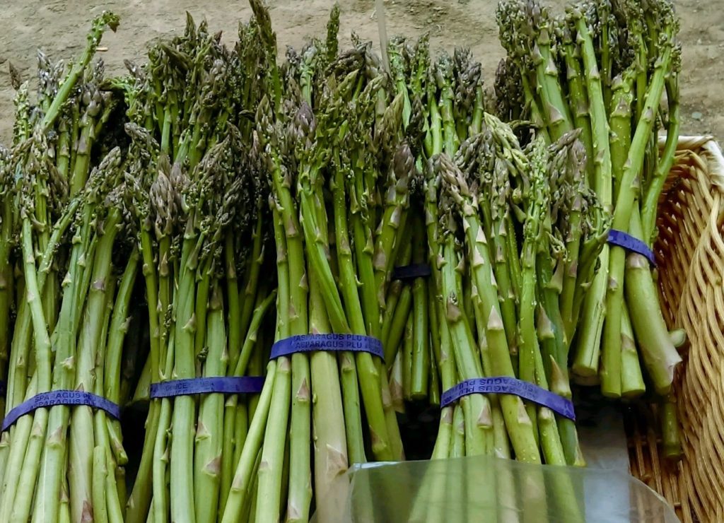 bunches of asparagus in a wooden basket